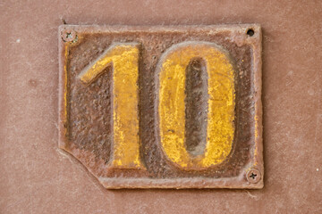 Old retro weathered cast iron plate number 10 closeup
