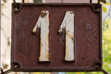 Old retro weathered cast iron plate number 11 closeup