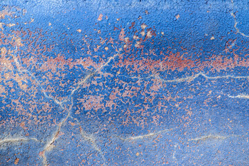 Faded indigo paint cracked wall closeup as blue background