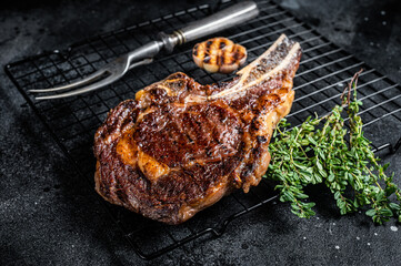 BBQ Grilled Tomahawk or rib eye with bone beef steak. Black background. Top view