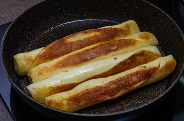 The cook fries pancakes for breakfast in a frying pan