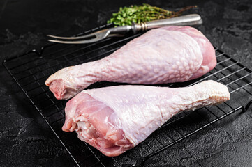 Raw turkey legs on a butcher table. Black background. Top view