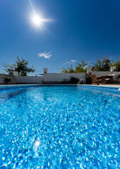 Fototapeta na wymiar Privater Pool im Garten einer Villa mit Wasser und Sonnenschein im Sommer