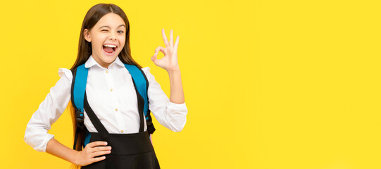winking happy child in school uniform carry backpack showing ok gesture, excellent pupil....