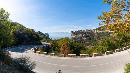 winding mountain road in with rock formations and autumn foliage forest colors