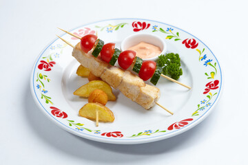 chicken kebab with sauce and vegetables