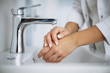 Woman doctor washing hands at hospital