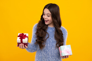 Amazed teenager. Child with gift present box on isolated studio background. Gifting for kids birthday. Excited teen girl.