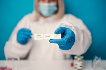 Doctor with surgical mask holding a blood sample. Researchers are inventing vaccines to treat COVID-19 virus. 