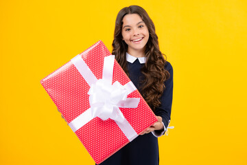 Fototapeta premium Teenager child with gift box, studio isolated background. Present for birthday, Valentines day, New Year or Christmas. Kid hold present box with gift ribbon bow.