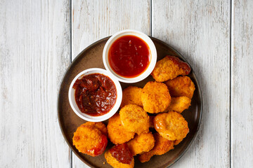 Top view of nuggets and bbq dips wooden surface