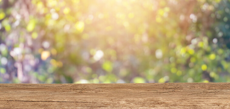 Wooden tabletop for product placement with a blury floral background. Place for displaying product mockups.