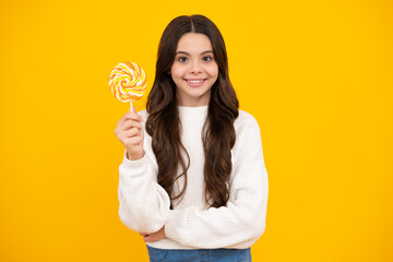 Teenager girl eating sugar lollypop. Candy and sweets for kids. Child eat lollipop popsicle over yellow isolated background. Yummy caramel, candy shop. Happy smiling girl.