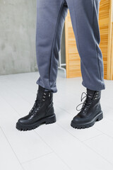 Black leather boots on women's legs. New collection of warm winter women's shoes