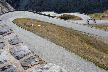 Gotthard Pass, Switzerland - September 18, 2022: Group of cyclists descending the Gotthard Pass, in...