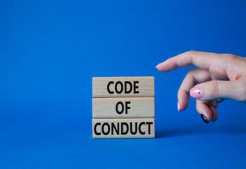 Code of conduct symbol. Wooden blocks with words Code of conduct. Beautiful blue background. Businessman hand. Business and Code of conduct concept. Copy space.