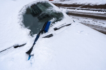 Cleaning car from snow. Concept of bad weather, snow storm