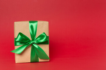 Gift box with green ribbon bow on color background