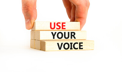 Use your voice symbol. Concept words Use your voice on wooden blocks on a beautiful white table white background. Businessman hand. Business and use your voice concept. Copy space.
