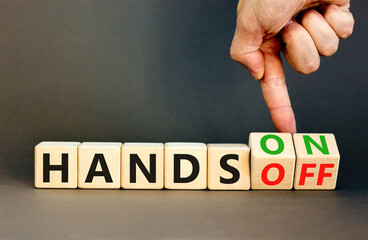 Hands on or off symbol. Concept words Hands on Hands off on wooden cubes. Businessman hand. Beautiful grey table grey background. Business hands on or off concept. Copy space.