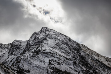 Obraz premium Mountains with snow-capped peaks. Beautiful panorama. Clouds over the mountains.