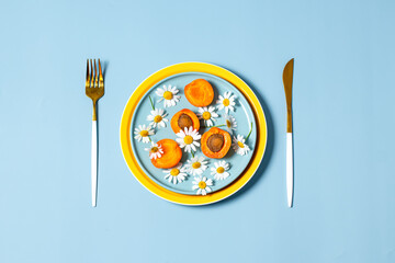 Plate with fruits and Daisies on blue. Organic natural backdrop .