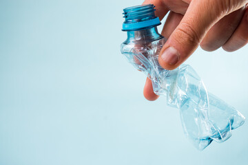 Hand taking plastic stripped bottle on blue background
