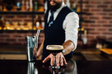 Fototapeta na wymiar Bartender serves finished black cocktail