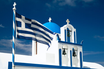 Greek church in Santorini, Greece with Greek flag.