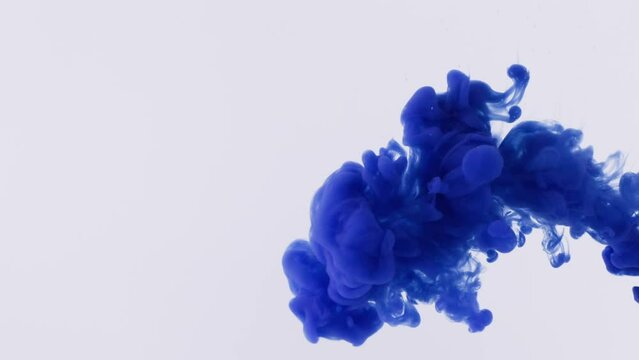 Blue liquid ink jet spreads in transparent water and creates interesting patterns. Blue paint splashes and gets great shape super slow motion