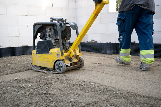 Arbeiter mit R&uuml;ttelplatte, Boden, Verdichtung, Schotter, Bauarbeiter, Baustelle, 
