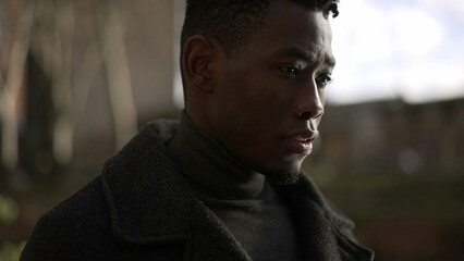 Pensive black man walking outdoors. Introspective pensive African guy thinking