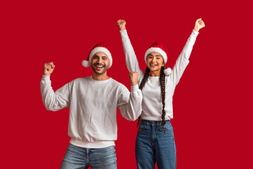Christmas Joy. Happy Excited Arab Couple In Santa Hats Celebrating Success