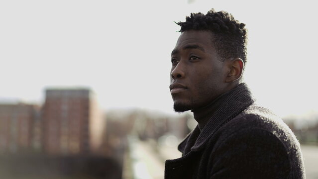 Pensive black man thinking about life on top of city bridge. Elegant African person close-up contemplative face