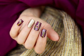 Plum golden manicure with sliders and rhinestones on square nails.