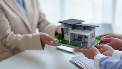 Real estate agents sell houses and land to customer by offering a model house as an example...