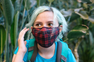 Teen girl with blue hair wearing a face mask