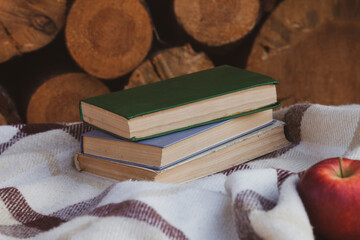 a close stack of old books on the woolen blanket  on wooden background in vintage style....