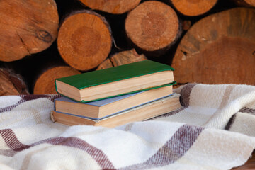 a close stack of old books on the woolen blanket  on wooden background in vintage style....