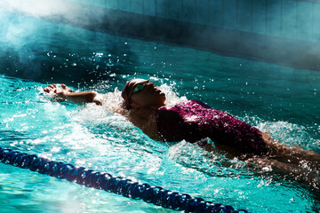 Young woman swimmer training in the pool. Professional swimmer inside the pool.