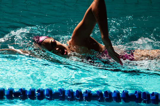Young woman swimmer training in the pool. Professional swimmer inside the pool.