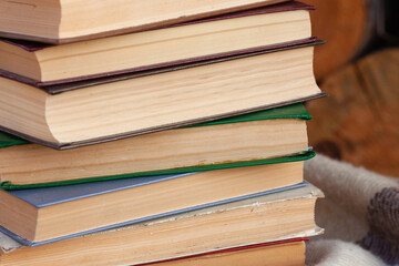 close stack of old books on the woolen blanket in vintage style on wooden background