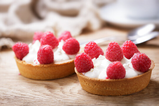 Sweet dessert. Tartlets with cream and raspberries