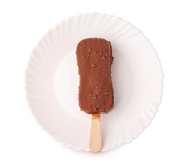 Сhocolate ice cream with pieces of nuts on a white plate