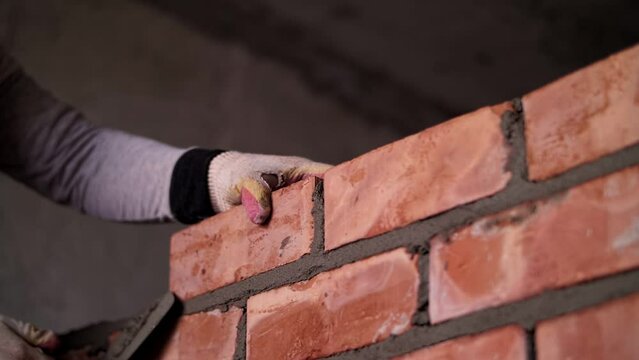 worker lays out a brick wall