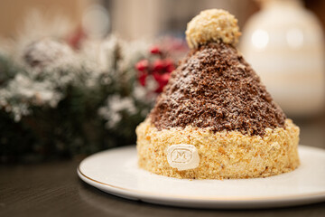 beanie hat shape christmas cake on a wooden table with white plate and floral wreath