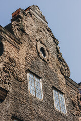 Old, retro, vintage building wall with wooden windows under blue sky.
