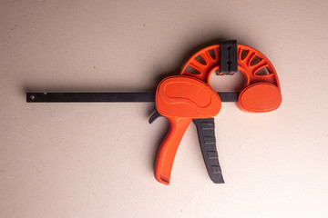 Joiner's clamp made of orange plastic. Joiner's hand tool.
