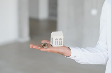 Real estate agent holding key and house model