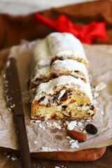 Christmas stollen cut into pieces on a wooden board.